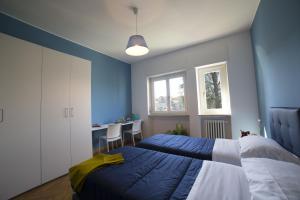米兰甘巴拉追梦斯公寓式酒店的一间蓝色卧室,配有两张床和一张桌子