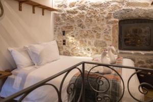 KrásionStefanis Guest House的一间卧室设有一张床和石墙