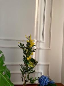 布雷西亚Hotel Livio的黄花在桌子上的花瓶里