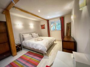 维伊勒佩Appartement au calme avec terrasse verdoyante entre Annecy et Genève的卧室配有白色的床和窗户。