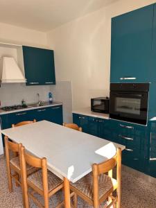 法诺Casetta sul Mare的厨房配有蓝色橱柜和桌椅