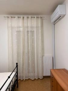 法诺Casetta sul Mare的卧室配有床和白色窗帘