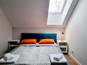 蒂黑Aparthotel Bukowa的一间卧室配有带橙色枕头的床和窗户。