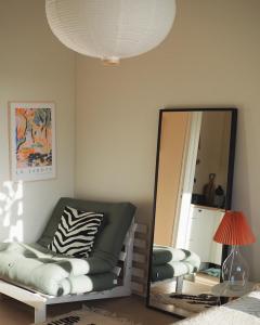 赫尔辛基Beautiful design studio in the heart of Kallio的客厅配有镜子、沙发和椅子