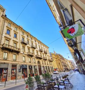 都灵Ana's Place Torino 2的建筑前方一条带桌椅的街道