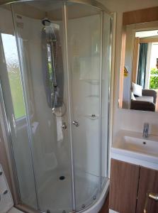 盖尔文Luxury Pods at Mornest Caravan Park, Anglesey的带淋浴和盥洗盆的浴室