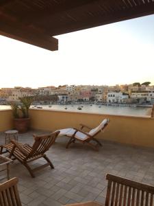 兰佩杜萨Attico sul Porto Vecchio - Lampedusa的市景阳台配有椅子