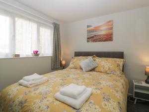 韦茅斯Lodmoor House的一间卧室配有黄色的床和毛巾