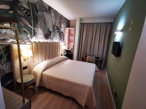 佛罗伦萨贝尔科尼酒店的一间小卧室,配有一张床和一面墙
