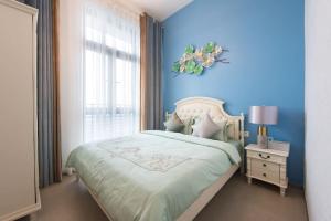 深圳WESU微宿行政公寓(深圳深大地铁店)的蓝色的卧室设有床和窗户
