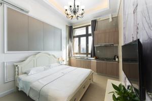 深圳WESU微宿行政公寓(深圳深大地铁店)的卧室配有一张白色大床和电视。