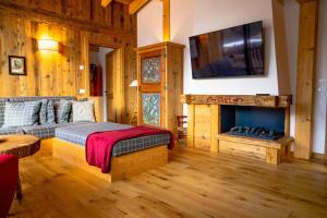 科瓦拉因巴迪亚Luxury Chalet Liosa - Ski in Ski out - Amazing view的一间卧室配有一张床和一个壁炉