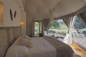 塔菲德尔瓦勒Glamping Tafí del valle的一间卧室设有一张大床和一个大窗户