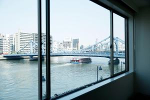 东京The Share Hotels Lyuro Tokyo Kiyosumi的从桥边的河流窗口欣赏美景