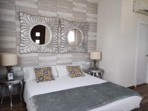 Premia de Dalt卡尔音乐住宿加早餐旅馆的一间卧室配有一张大床和两面镜子