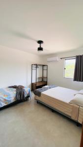 伦索伊斯Vila Dos Diamantes - Lencois Bahia的一间卧室设有两张床和窗户。
