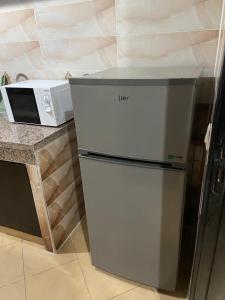 DerouaMohammed V Airport HOME的厨房里配有冰箱,厨房旁边设有微波炉