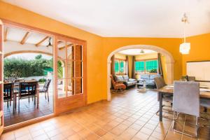 卡尔佩Villa Oceanic - PlusHolidays的一间带橙色墙壁的客厅和一间餐厅