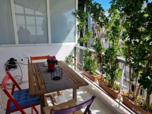雅典Modern studio apartment B的阳台配有木桌、椅子和植物