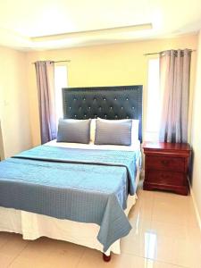 波特莫尔Bay Front Apt 208的一间卧室配有蓝色的床、梳妆台和窗户。