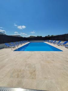 Biville-sur-MerLA CASA的一个带躺椅和蓝色的游泳池