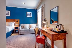 爱丁堡Toby Carvery Edinburgh West by Innkeeper's Collection的酒店客房配有书桌和床。