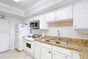 格尔夫海岸Ocean House II 2602的厨房配有白色橱柜和白色冰箱。