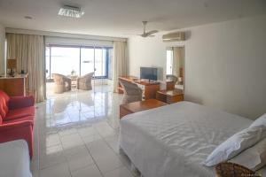 布希奥斯Barracuda Eco Resort Búzios的一间卧室设有一张床和一间客厅。