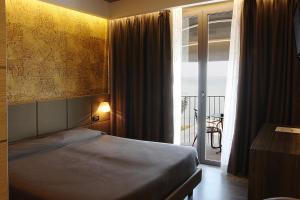 西尔米奥奈奥罗拉酒店的一间卧室设有一张床和一个阳台的窗户。