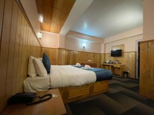 拉冲Montanamar Lachung的酒店客房设有一张大床和一张书桌。