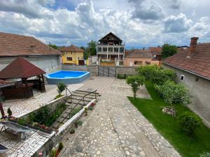 奥勒什蒂耶Pensiunea Roșu的一个带游泳池和房子的后院