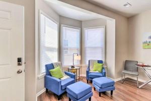 弗兰特罗亚尔Newly Renovated, Quaint, Modern 2-Bedroom Loft的一间设有两张蓝色椅子和一张桌子及窗户的房间