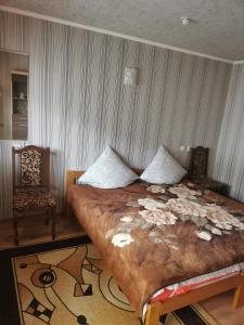 喀尔巴阡Cottage 5的一间卧室配有一张大床和一把椅子