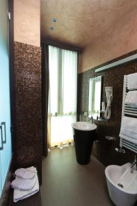 西尔米奥奈奥罗拉酒店的一间带水槽、浴缸和镜子的浴室