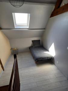 蓬托尔松Maison au pied du Mont Saint Michel 2的阁楼上设有一张床铺的房间,设有窗户