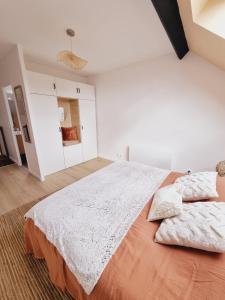 Neauphle-le-ChâteauDuplex neuf centre ville avec parking的白色卧室配有一张带两个枕头的大床