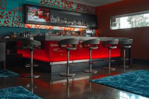 洛杉矶SIRTAJ – Beverly Hills的酒吧,设有黑凳子和红色柜台