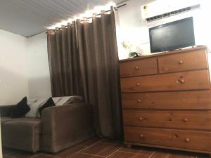 里约热内卢Apartamento aconchegante com deck的一间卧室配有梳妆台、沙发和梳妆台