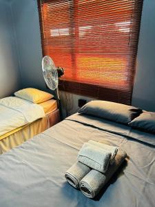 OmuthiyaEtosha/Omuthiya 2 Bedroom的一间卧室设有两张床、风扇和窗户。