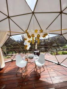 瓜塔维塔Golden Glamping的一个带吊灯的庭院里的玻璃桌子和椅子