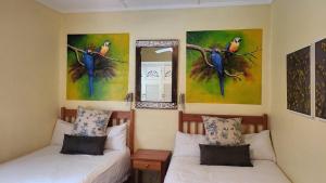 爱德华港Caribbean Estates Montego bay 30的墙上画作的房间里设有两张床