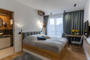 威利兹卡mN apartments home - Wieliczka Town的一间卧室配有一张床和一张书桌