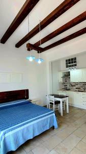 玛丽娜迪曼卡维萨Lu Salentu Chalet Beach的一间卧室配有一张蓝色的床和一张桌子