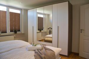 迪楚姆MS-Apartments I Ferienhaus Sielterrasse Ditzum的一间带大镜子和床的卧室