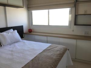 里约热内卢Apartamento Bora Bora Resort的卧室配有白色的床和窗户。