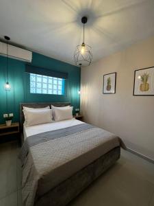 波托什Veni's Apartments的一间卧室设有一张床和蓝色的墙壁