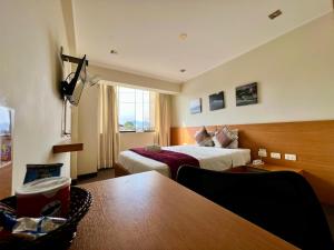 特鲁希略Hotel Médano的酒店客房设有两张床和一张桌子。