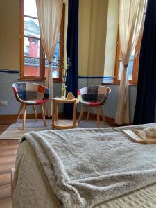 阿姆佩佐Residenza d'Epoca Albergo Grimani的一间卧室配有两把椅子和一张带毯子的床