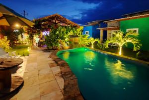 皮帕Chalés Pipa Brasil的夜间房子后院的游泳池