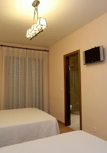 拉耶斯萨尔瓦多特哈尔乡村旅馆的一间卧室配有一张床和一台平面电视